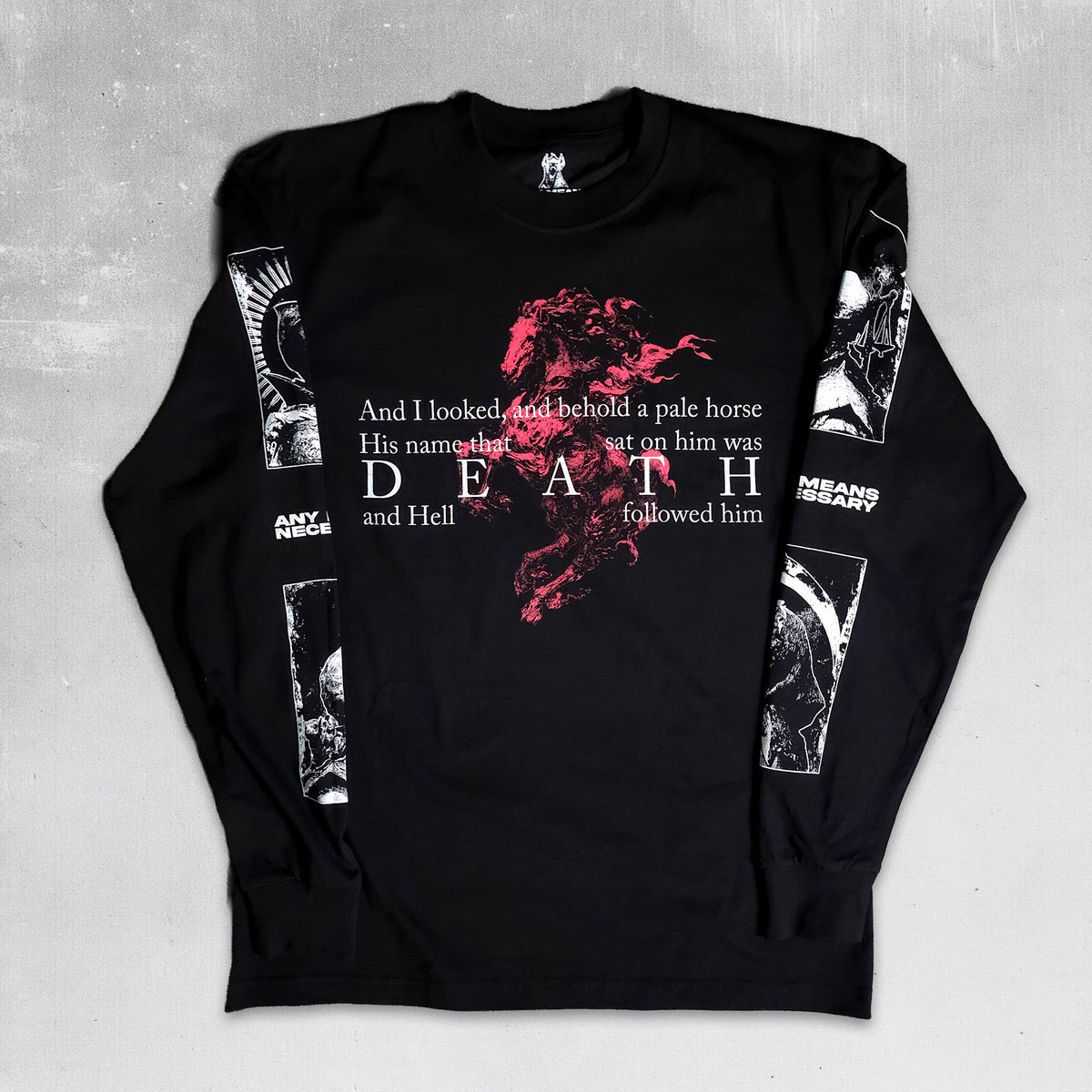 A black long-sleeve graphic t-shirt laid flat on a textured gray background. The front features a red and white graphic of a horse with the text 'And I looked, and behold a pale horse His name is Death and Hell followed him'.