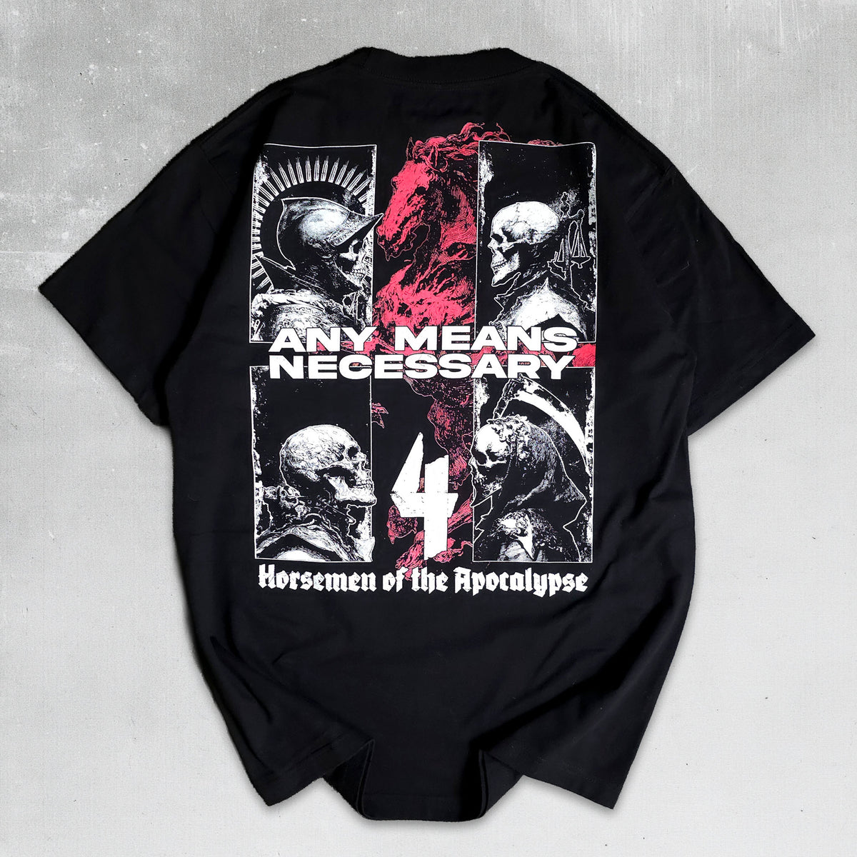 A black short-sleeve graphic t-shirt laid flat on a textured gray background. The shirt features a large back print with four panels of black and white skulls and a central red graphic, overlaid with the text 'ANY MEANS NECESSARY', a large white number '4', and 'Horsemen of the Apocalypse'.