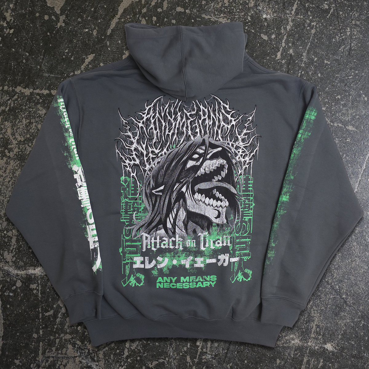 A dark gray hoodie laid flat on a textured dark surface, showing the back graphic. The design features a large black and white shark illustration with green text and Japanese characters, and green distressed graphics running down both sleeves.