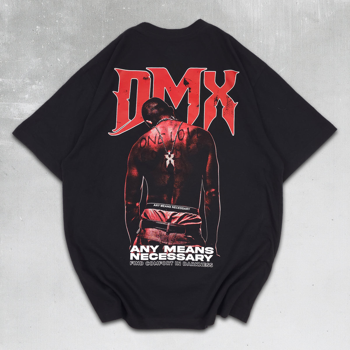 A black oversized short-sleeve t-shirt featuring a large graphic print on the back. The graphic displays the text 'DMX' in a stylized red font above an illustration of a shirtless man with 'ONE LOVE' written on his back, with additional text below.