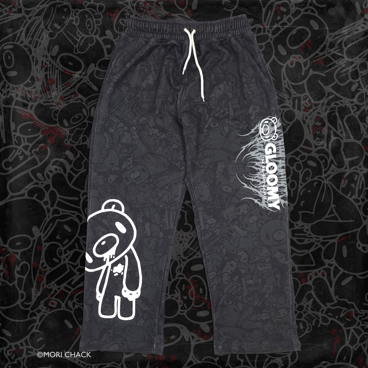 Black shorts featuring a white outline cartoon bear graphic on the left leg and vertical white 'GLOOMY' branding with smaller text on the right leg, shown against a dark textured background.