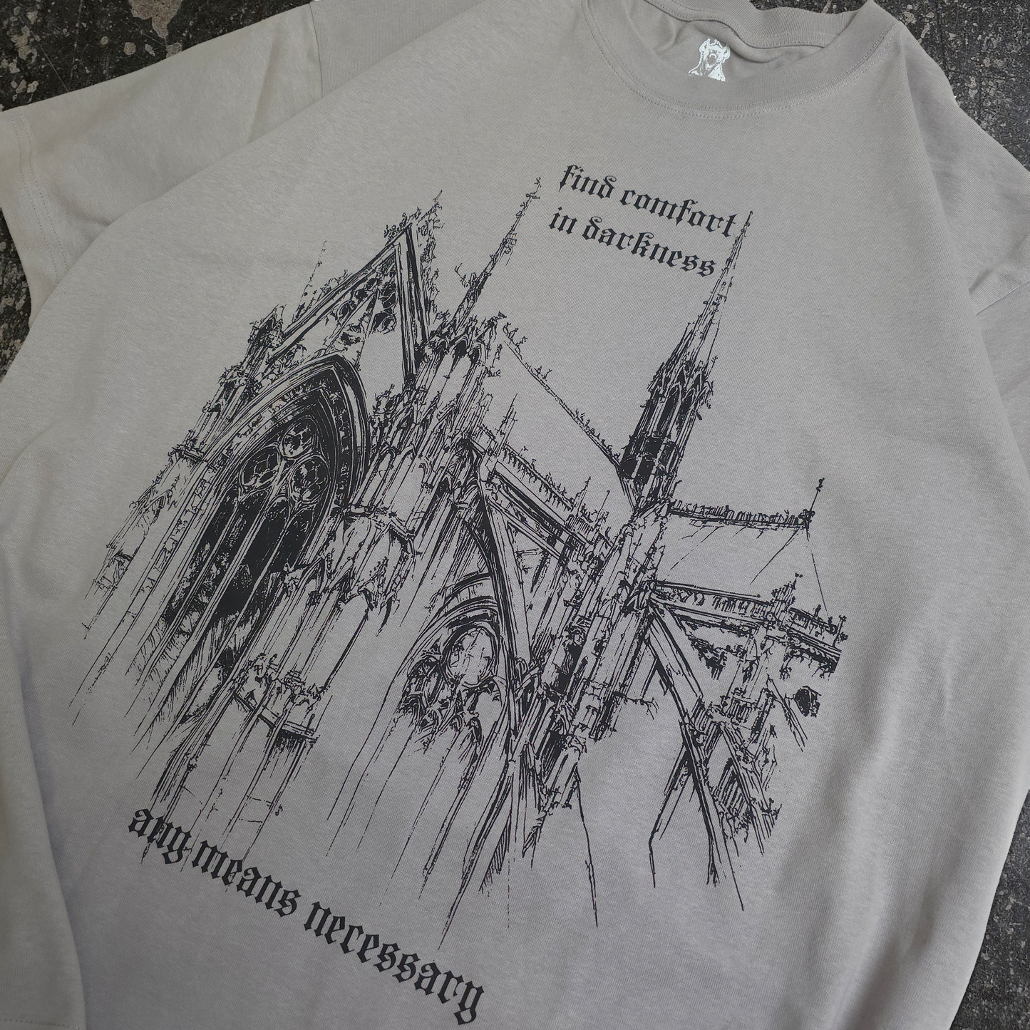 Gray t-shirt with black architectural design and text on a textured surface