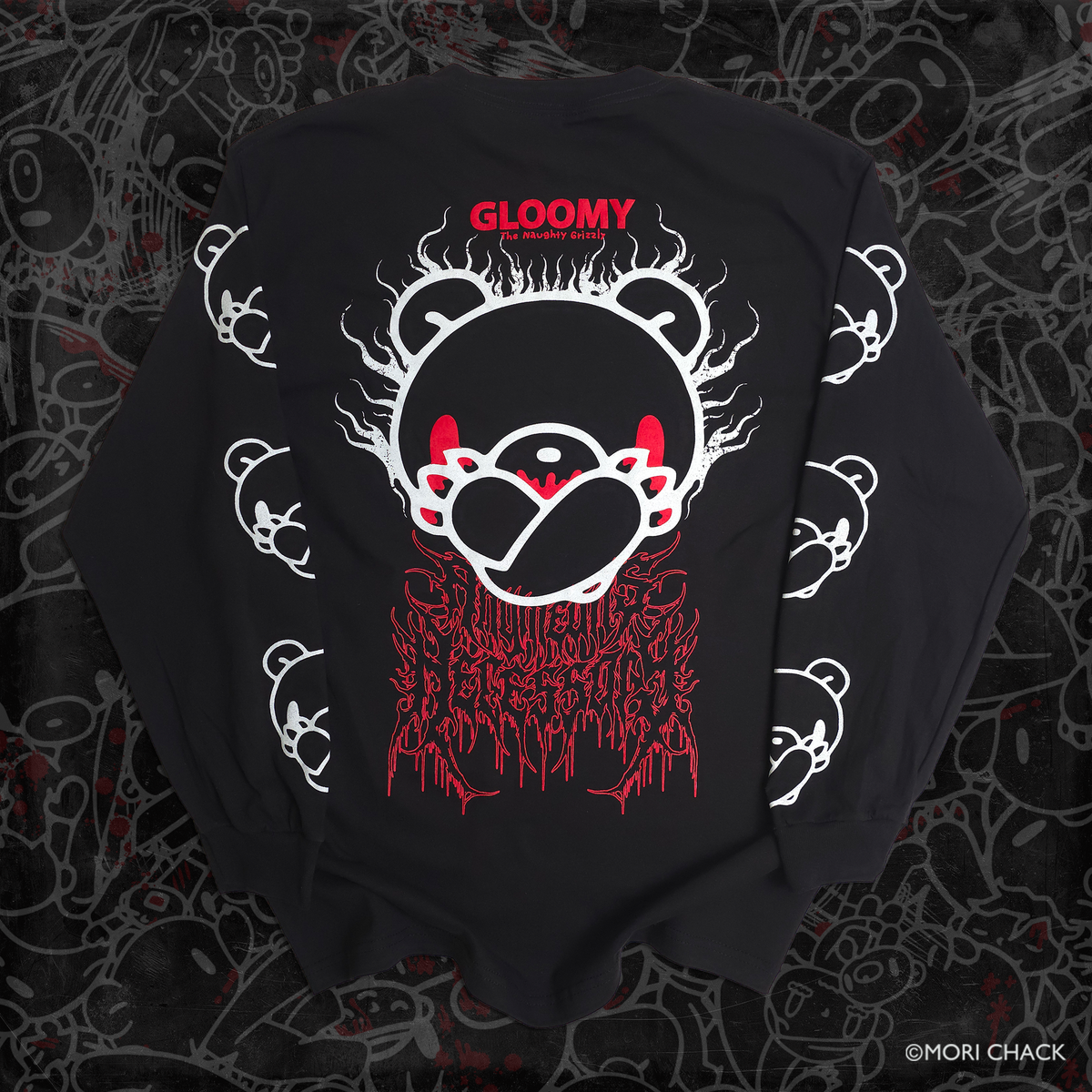 A black long-sleeve sweatshirt laid flat, featuring a large graphic print of a bear face with white outlines and red details, including the text 'GLOOMY' and 'KARAOSE' on the chest, with additional white and red graphic elements on the sleeves and lower front. The sweatshirt is photographed on a dark, patterned background.