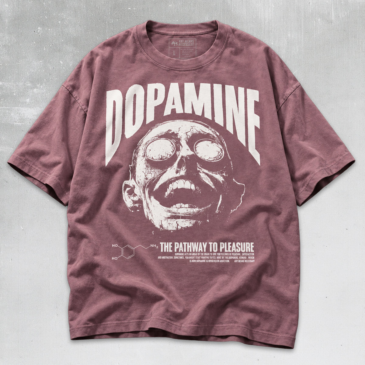 A dusty rose short-sleeve graphic t-shirt featuring a white distressed print of a skull-like face, the word 'DOPAMINE' in large arched letters, and 'THE PATHWAY TO PLEASURE' with chemical structures below, laid flat on a textured gray background.