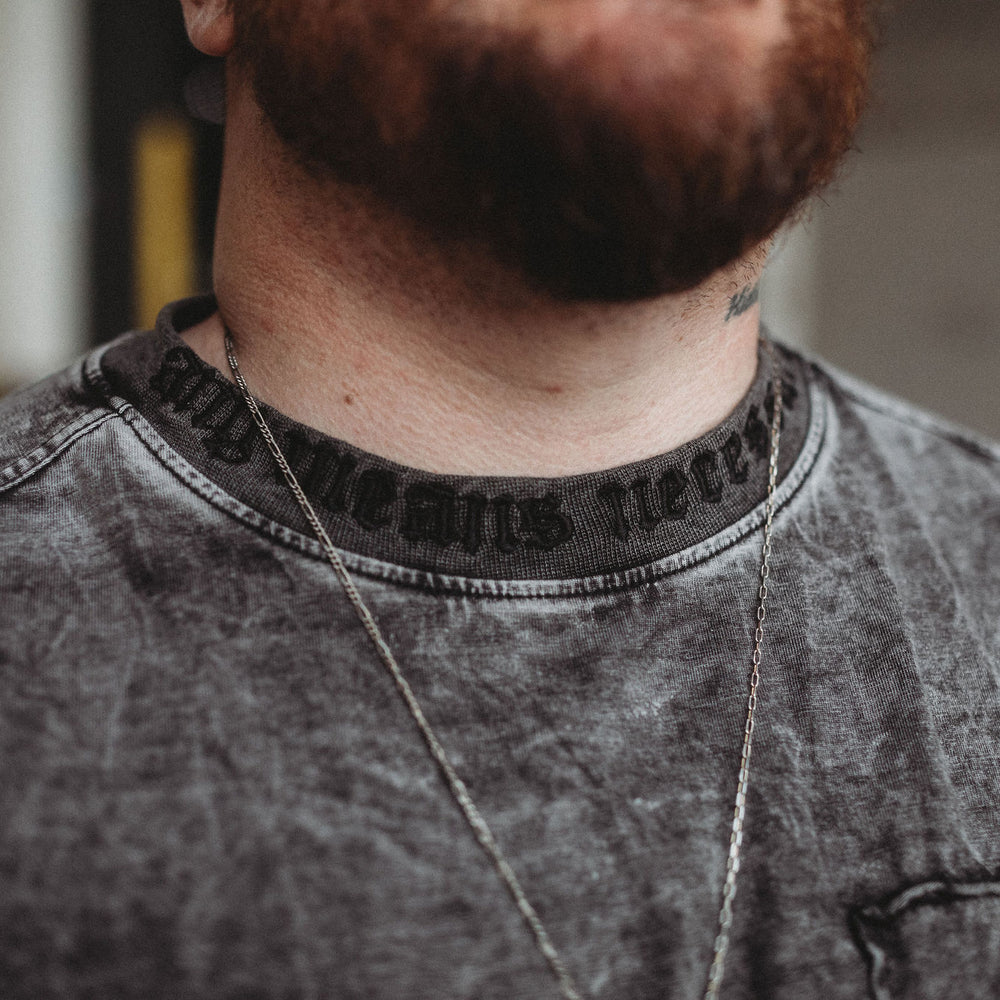 
                      
                        Close-up of a person wearing a gray shirt with a blurred background
                      
                    