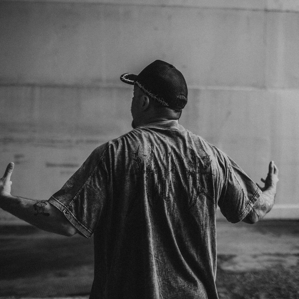 
                      
                        Person standing with arms outstretched in front of a plain wall
                      
                    