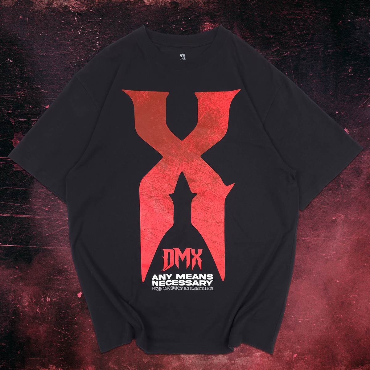 A black short-sleeve t-shirt with a large distressed red graphic on the front. The graphic features a stylized letter 'X' with a silhouette of a soldier inside, the text 'DMX', and 'ANY MEANS NECESSARY' printed below in red and white.