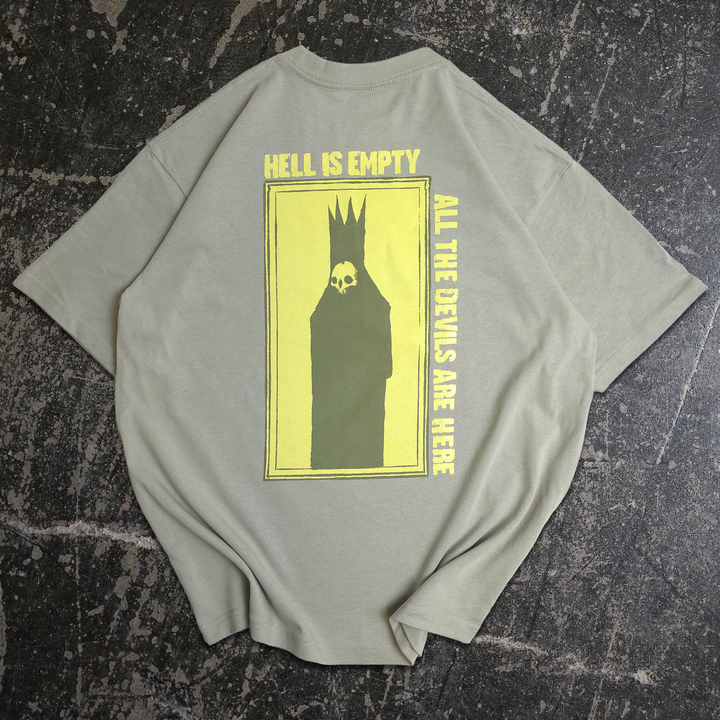 Light green t-shirt with yellow text and graphic on a textured black surface