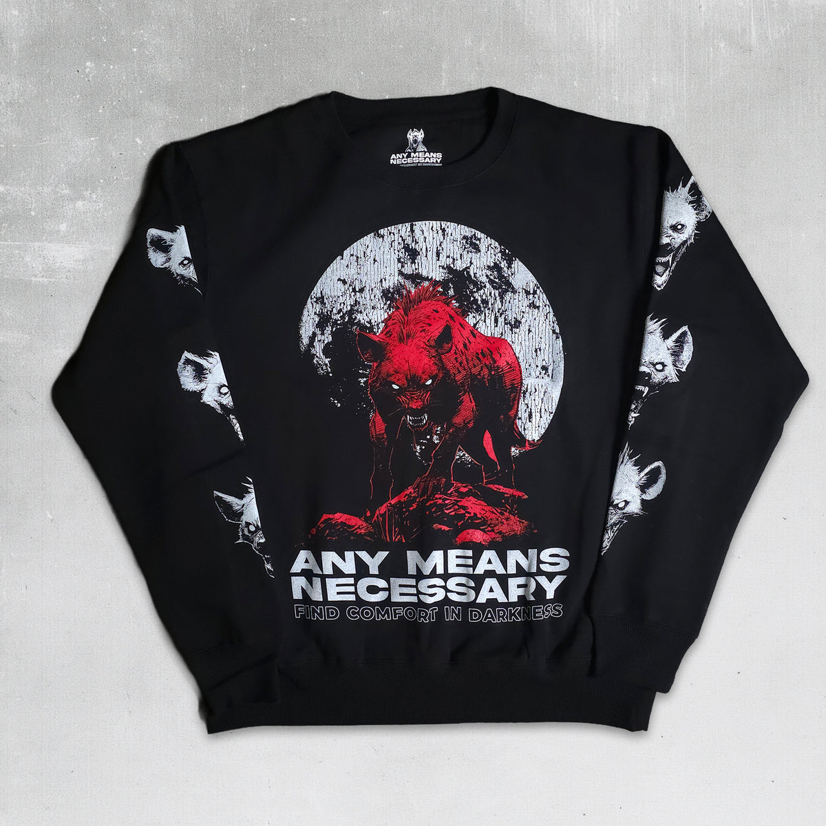 A black crewneck sweatshirt featuring a graphic print of a red werewolf in front of a white full moon, with the text 'ANY MEANS NECESSARY' and 'FED COMFORT IN DARK TIMES' on the front. The sleeves feature white wolf head illustrations, and the inner neck displays the 'Wicked City' brand logo.