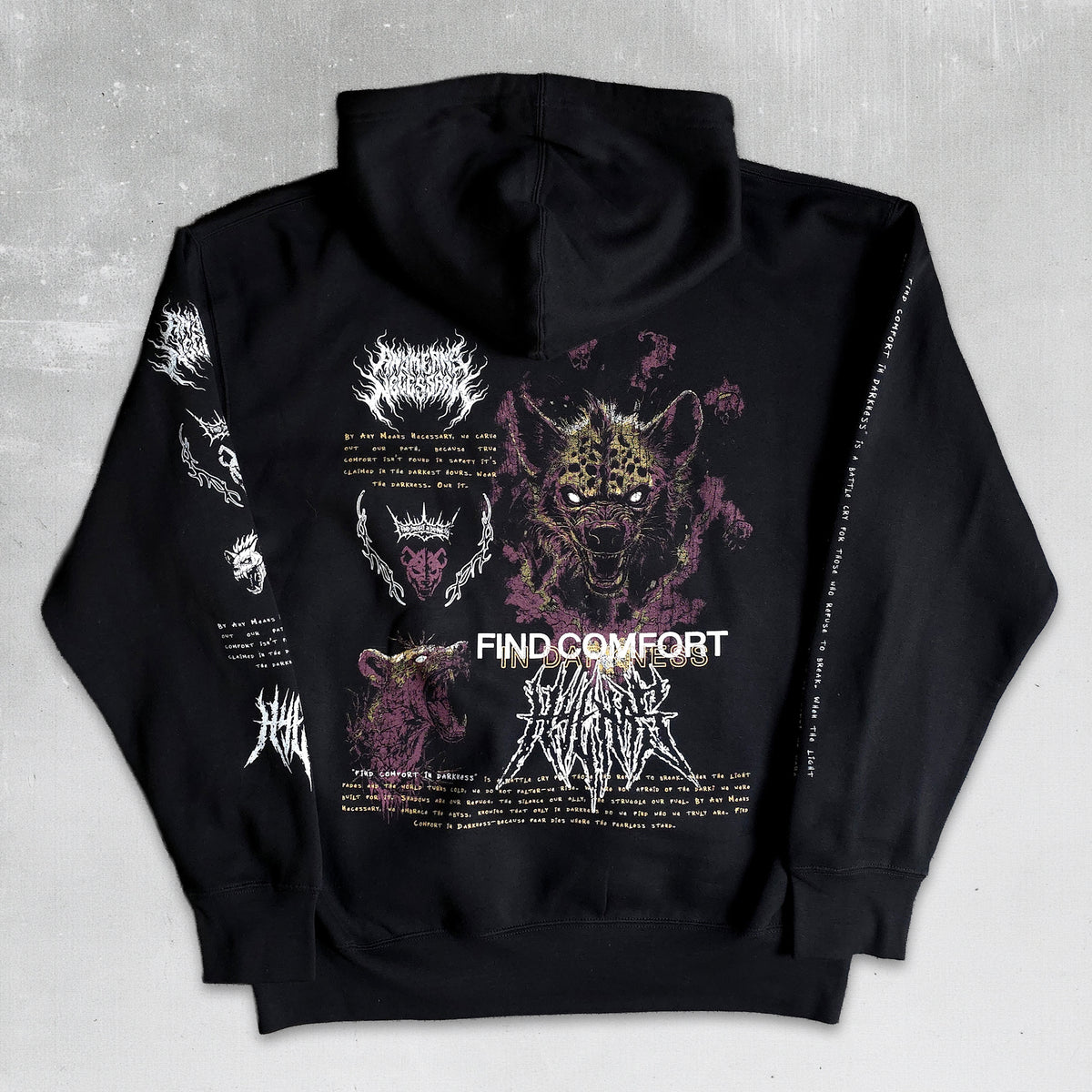 Black hoodie shown from the back with a large graphic print featuring a cat-like face, purple and white text, and multiple band logos, photographed on a light gray textured background.
