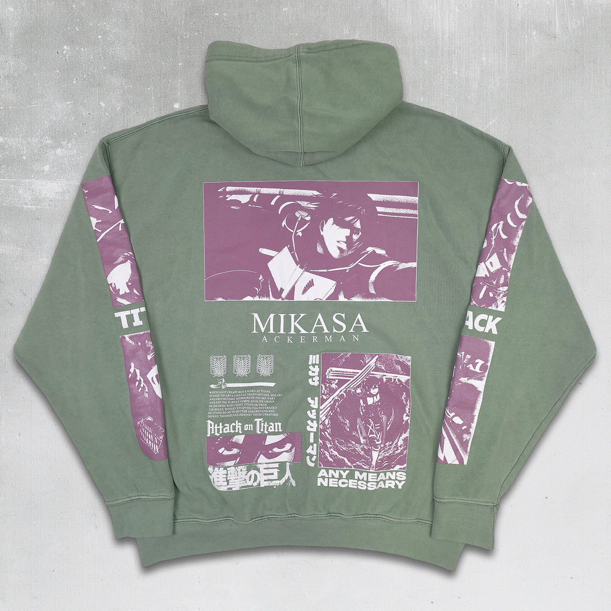 An olive green pullover hoodie shown from the back, featuring a large purple and white graphic print with the text 'MIKASA JACKERMAN' and anime-style artwork, laid flat on a dark textured surface.
