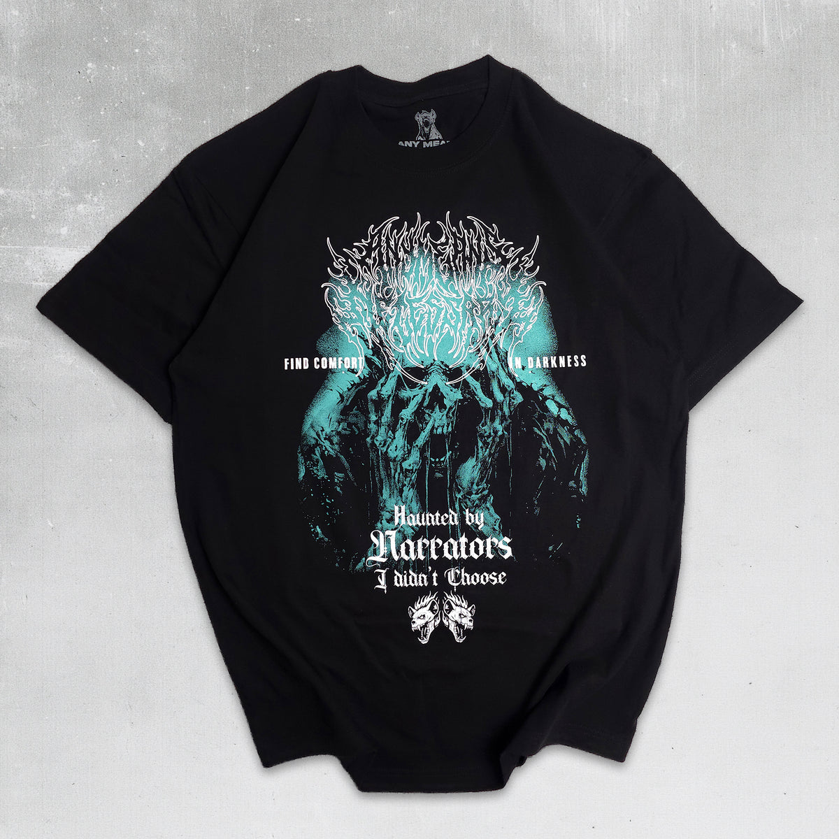 A black short-sleeve graphic t-shirt laid flat on a textured gray background. The front of the shirt features a large, detailed graphic of a skull with glowing teal and white details, accompanied by gothic text that reads 'FOOD FOR CARNAGE IN DARKNESS' and 'Haunted by Narrators I Didn't Choose'.