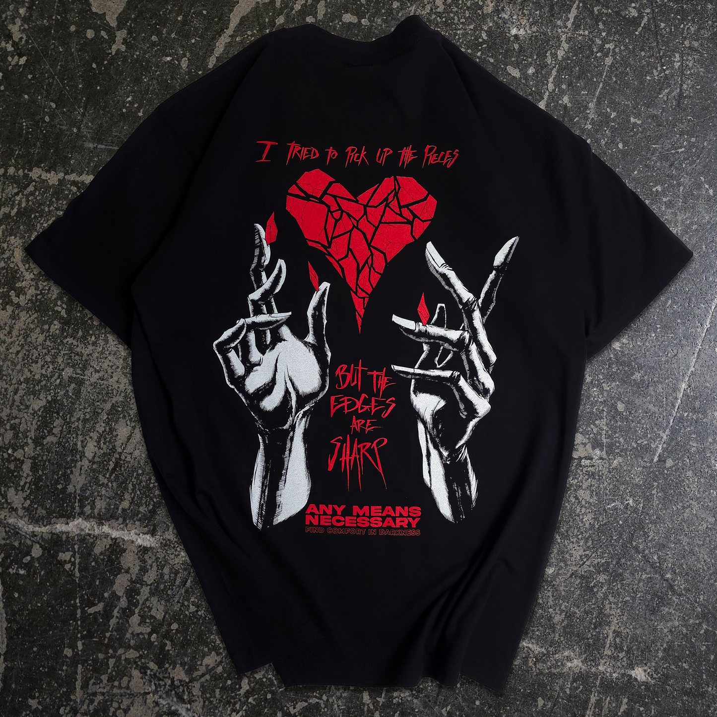 Black t-shirt with red and white graphic design on a white background
any means necessary shawn coss sharp edges t shirt black broken heart with hand drawn hands