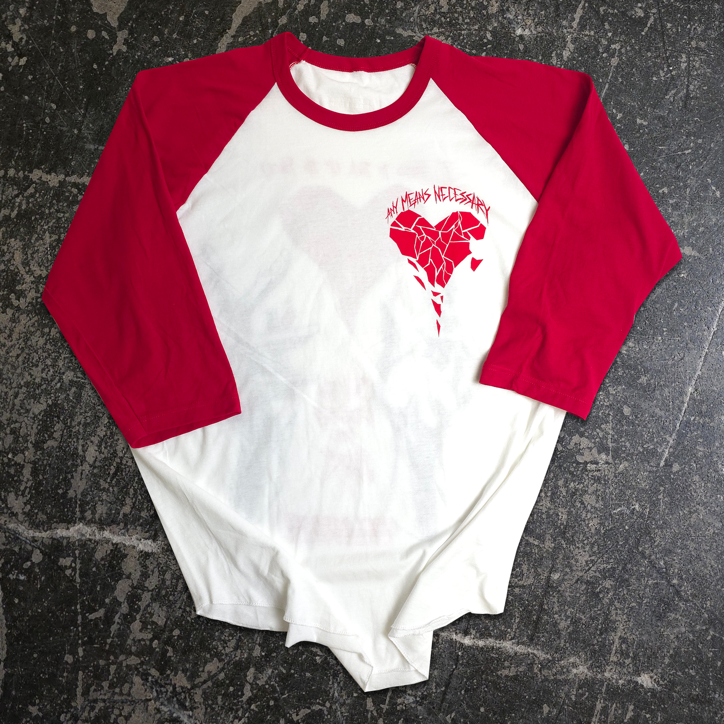 Red and white baseball-style shirt with a heart design on a textured black surface